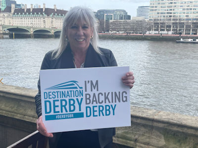 Amanda Solloway MP holding an 'I'm backing Derby' sign