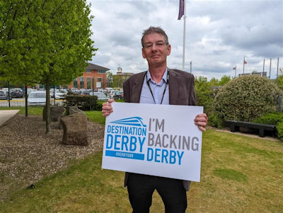 Andrew Botham holding an 'I'm backing Derby' sign