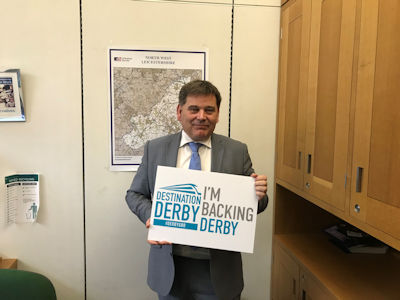 Andrew Brigden MP holding an 'I'm backing Derby' sign