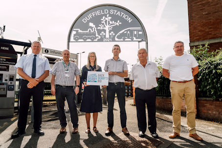 Derwent Valley Line Community Rail Partnership holding a 'Back Derby's Bid' sign outside Duffield train station