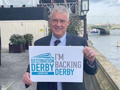 Lee Anderson MP holding an 'I'm backing Derby' sign