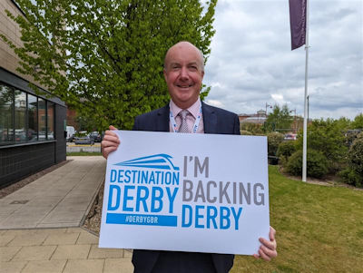 Michael Hulme holding an 'I'm backing Derby' sign