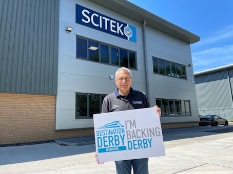 SCITEK colleague holding an 'I'm backing Derby' sign